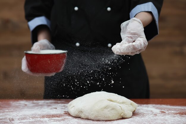 el cocinero hace harina con harina para hornear en la mesa