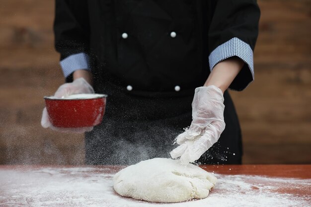 el cocinero hace harina con harina para hornear en la mesa