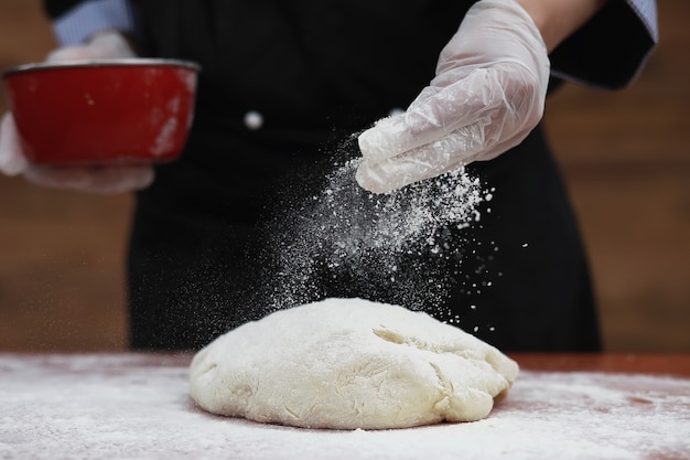 el cocinero hace harina con harina para hornear en la mesa