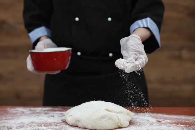 el cocinero hace harina con harina para hornear en la mesa