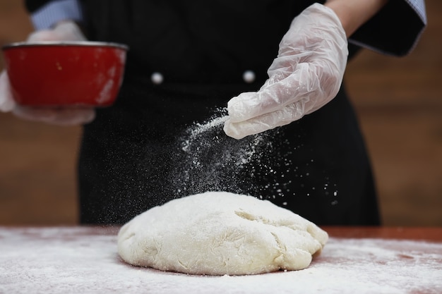 el cocinero hace harina con harina para hornear en la mesa