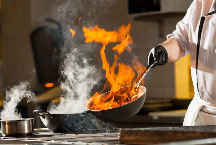 Foto cocinero haciendo la cena en la cocina del restaurante de alta gama.