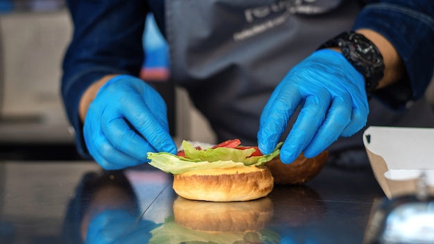 Cocinero haciendo hamburguesas en un camión de comida