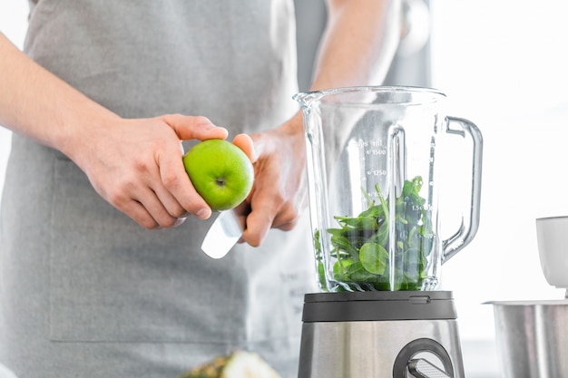 Cocinero del hombre joven que cocina o que prepara el batido