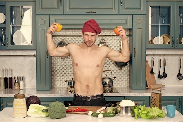 cocinero hombre musculoso cocinero en la cocina en casa fotografía de chef cocinero hombre en la cocina con comida saludable