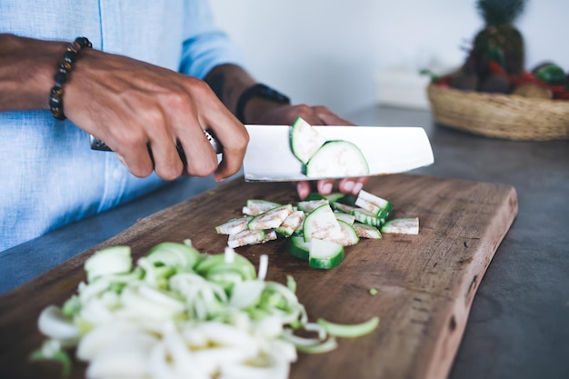 Cocinero irreconocible cortando verduras a bordo