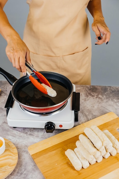 Cocinero latinoamericano preparando y friendo tequenos venezolanos aperitivo latino