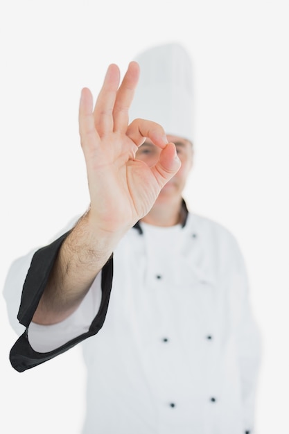 Foto cocinero maduro en uniforme mostrando signo ok