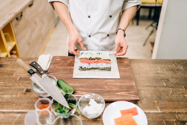 Cocinero masculino haciendo sushi, cocina asiática