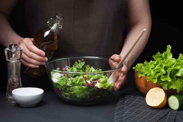 Foto cocinero de la mujer en la cocina que prepara la ensalada.