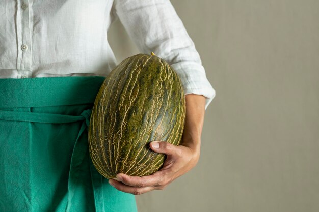 Cocinero de la mujer que sostiene un melón verde foto de archivo