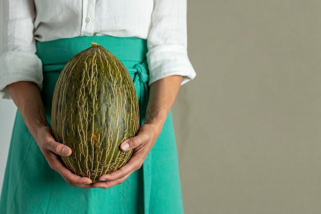 Cocinero de la mujer que sostiene un melón verde foto de archivo