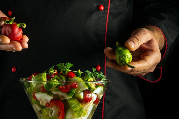 El cocinero prepara una ensalada con verduras frescas en la cocina del restaurante Plato de verduras en un cuenco de desayuno Concepto de comida saludable vegetariana