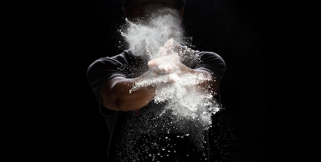 El cocinero prepara polvo de harina blanca para cocinar comida de panadero El anciano aplaude a la mano El cocinero aplaude la mano