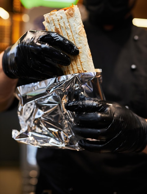 el cocinero prepara shawarma cocina shawarma restaurante callejero Doner Kebab en un asador