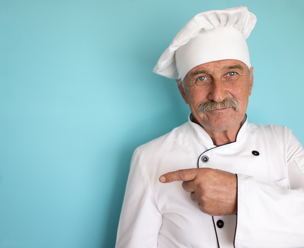 Cocinero Senior con bigote apuntando a espacio de copia