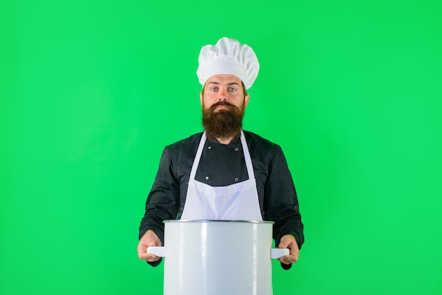 Cocinero de sexo masculino que cocina con el cocinero profesional de la olla en uniforme y el sombrero sostiene el cocinero del pan en uniforme