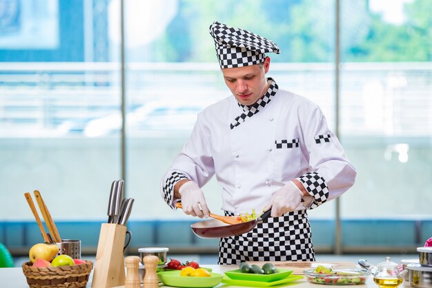 Cocinero de sexo masculino que prepara la comida en la cocina