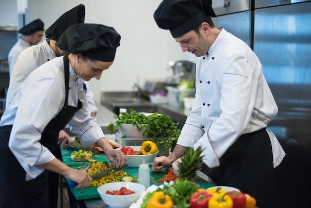 Cocineros y chefs de equipos profesionales que preparan comidas en la cocina de un hotel o restaurante ocupado