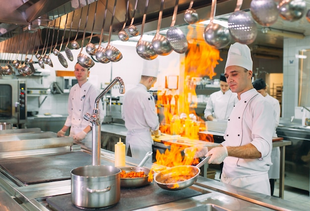 Los cocineros preparan las comidas en la estufa en la cocina del restaurante u hotel.