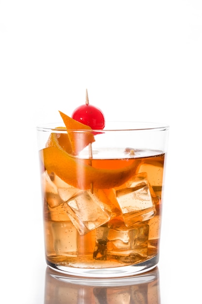 Cocktail à moda antiga com laranja e cereja isolado no branco