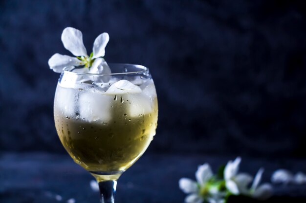 Cocktail alcoólico de maçã com vinho espumante em copo com flores