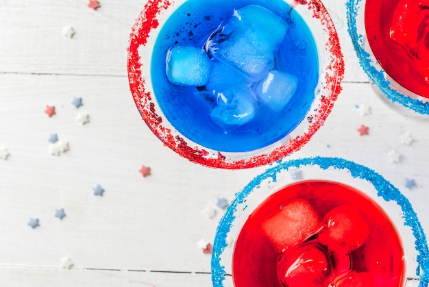 Cocktail alcoólicos caseiros, perfurador em cores tradicionais - vermelho, azul, branco. Com gelo. Na mesa da cozinha de casa. Copie o espaço perto da vista superior