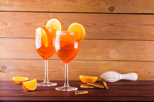 Cocktail Aperol Spritz auf Holzbrettern Zwei Gläser Aperol spritz Cocktail mit Orangenflecken