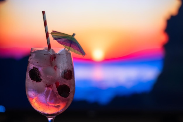 Cocktail auf der Theke einer Strandbar bei Sonnenuntergang, alkoholisches Getränk mit Beerenfrüchten