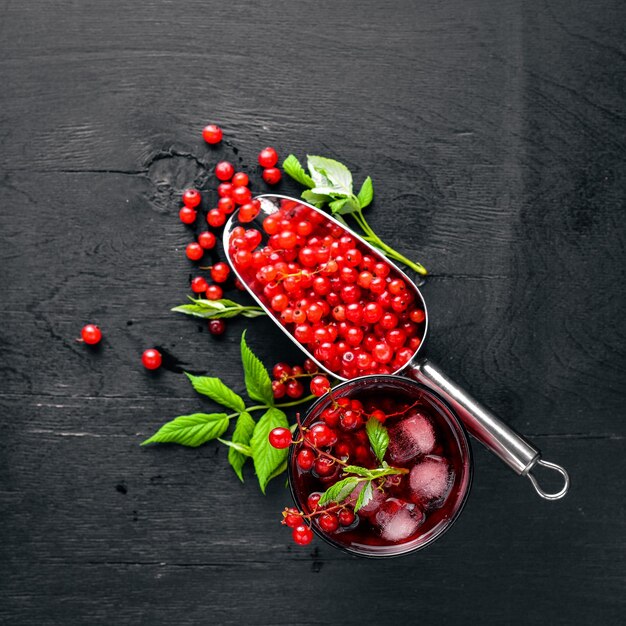 Cocktail aus frischer roter Johannisbeere mit Eis auf einem hölzernen Hintergrund Draufsicht Freier Speicherplatz