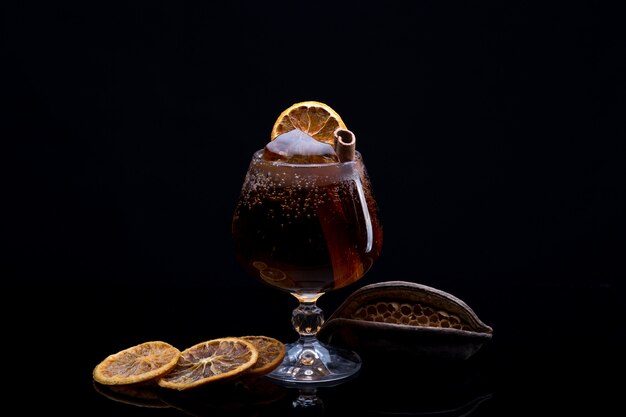 Cocktail com refrigerante de cola, gelo, canela e limão