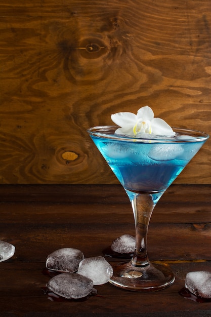 Cocktail cosmopolita azul no fundo de madeira