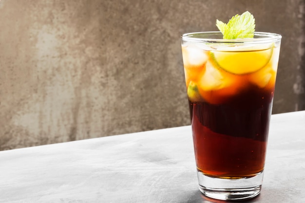 Cocktail Cuba Libre em um vidro em um fundo escuro. Copie o espaço. Fundo de alimentos