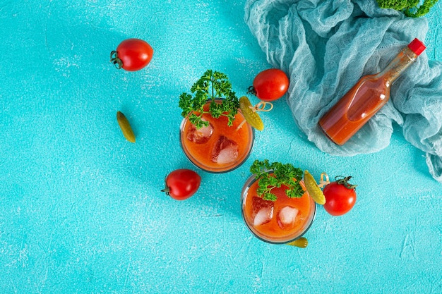 Cocktail de álcool bloody mary sobre fundo azul. coquetel clássico com suco de tomate e vodka. vista do topo