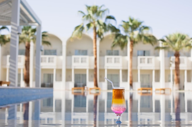 Cocktail de arco-íris à beira de uma piscina de resort Conceito de férias de luxo Piscina exterior Horizontal