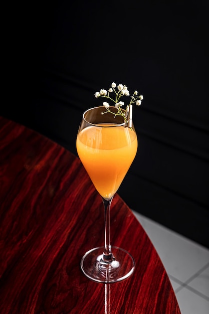 Cocktail de baixo abv Bellini em copo de flauta decorado com flores