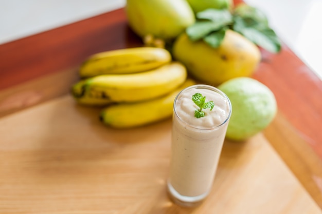 Cocktail de banana e bananas frescas em fundo de madeira