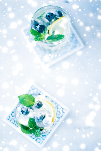 Cocktail de férias de inverno com gelo e neve brilhante no fundo da receita do menu de Natal