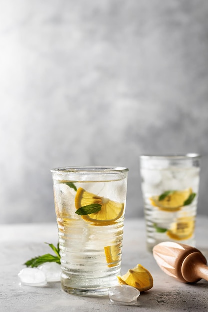 Cocktail de limonada ou mojito com hortelã-limão e espremedor de madeira gelado de verão bebida refrescante em fundo cinza