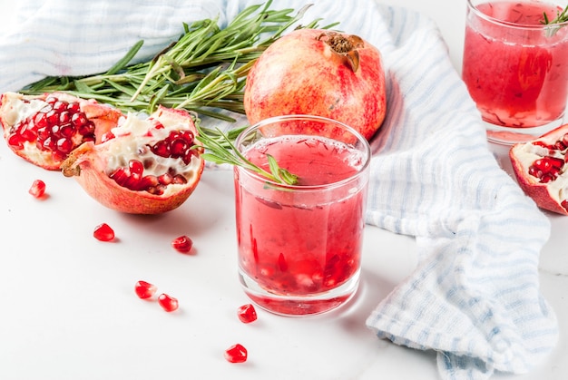 Cocktail de romã alcoólica embriagado caseiro com alecrim e vodka, mármore branco,