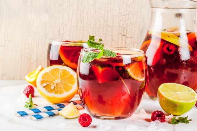 Cocktail frio de verão, sangria de frutas e bagas brancas com maçã, limão, laranja e framboesa