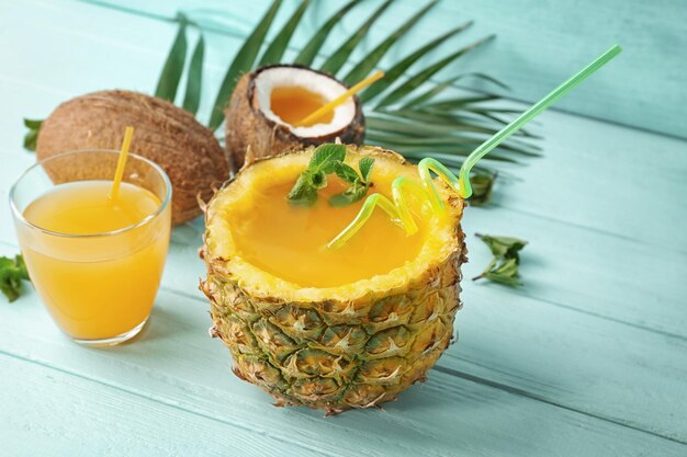 Cocktail in Ananas auf Holztisch