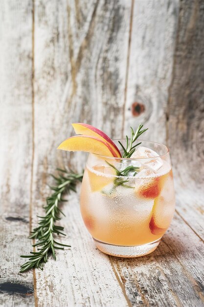 Foto cocktail de melocotón y romero en un fondo de madera