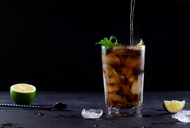 Cocktail mit Cola, dekoriert mit Limettenscheiben