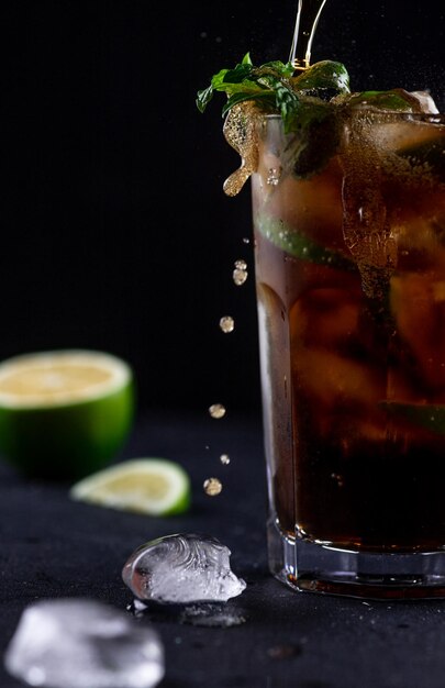 Cocktail mit Cola, dekoriert mit Limettenscheiben