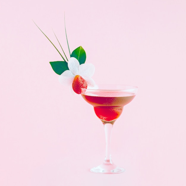 Foto cocktail mit erdbeeren, blumen und tropischen blättern dekoriert