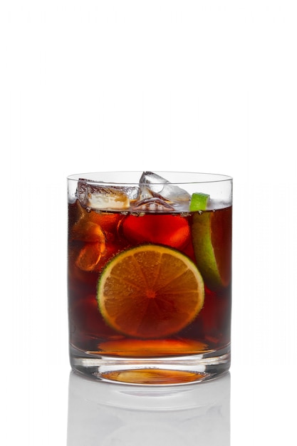 Cocktail mit Rum und Kolabaum mit Eis, Kalk und Zitrone im altmodischen Glas lokalisiert auf Weiß