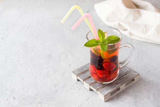 Cocktail mit schwarzer Johannisbeere, Erdbeere, Minze und Limette. Abkühlendes Sommergetränk.