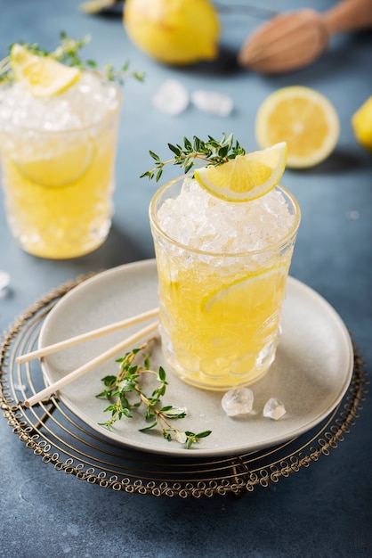 Cocktail mit Zitrone, Timo und Crushed Ice auf dem dunklen Hintergrund, Bar-Konzept und selektivem Fokusbild