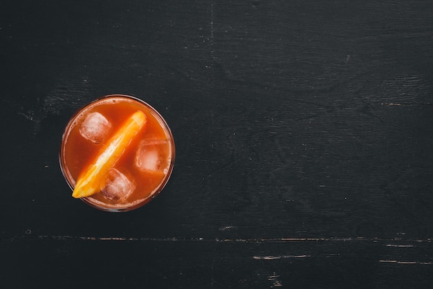 Cocktail Negroni Orange und Whisky auf einem hölzernen schwarzen Hintergrund Ansicht von oben Kopieren Sie Platz